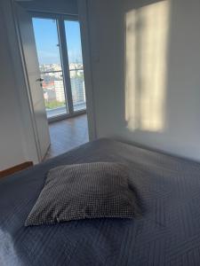 - une chambre avec un lit et un oreiller dans l'établissement Kasprzaka Beautiful City View Apartament, à Varsovie
