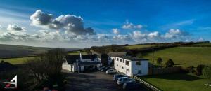 eine Gruppe von Autos, die vor einem Gebäude geparkt sind in der Unterkunft The West Country Inn in Clovelly