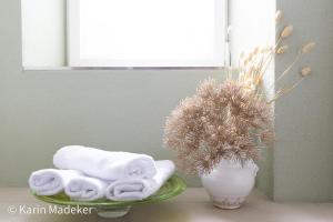 a table with towels and a vase with a plant at Design Ferienwohnung mit Bauerngarten in Waldkirchen