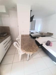 Habitación con 2 camas, mesa y silla en Flats for you Bueno, en Goiânia