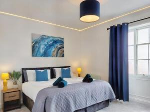 1 dormitorio con 1 cama grande con almohadas azules en The Yorkshire Hosts - Langton Lodge Apt.8, en Wakefield