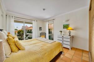 a bedroom with a bed and a large window at Vila Sol with Pool, Garden & Rooftop Terrace in Quarteira +44 photos