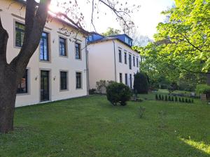 une grande maison blanche avec une cour verdoyante dans l'établissement Gästehaus Villa Seraphinum, à Dresde