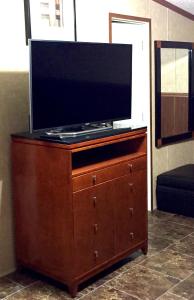 TV de pantalla plana en una cómoda de madera en Grand Inn, en Big Lake