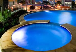 uma grande piscina azul no topo de um edifício em Pandanas Apt 7 15th fl with harbour and city views em Darwin