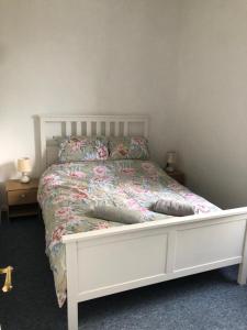 a bedroom with a white bed with flowers on it at The Caledonian House in Bath