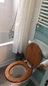 a bathroom with a toilet with a wooden seat at The Caledonian House in Bath