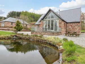 a house with a pond in front of it at Glen Cruick in Kirriemuir