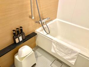 a bathroom with a shower and a toilet and a sink at Henn na Hotel Osaka Namba in Osaka