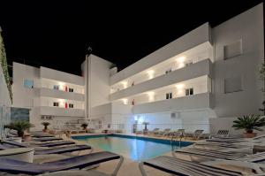 un hotel con piscina y tumbonas en All Suite Ibiza Aparthotel en San Antonio