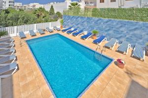 a swimming pool with lounge chairs and a swimming pool at All Suite Ibiza Aparthotel in San Antonio