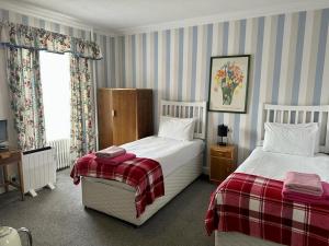 a hotel room with two beds and a television at Eliza House in Edinburgh