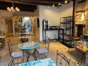 ein Restaurant mit Tischen und Stühlen in einem Raum in der Unterkunft Logis Hôtel la Vallée de l'Arc in Trets