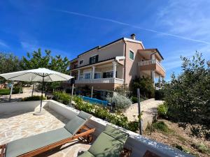 a villa with a swimming pool and a house at Apartments JoDi pool Novalja in Novalja