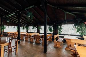 a dining room with wooden tables and benches at Restoran i sobe Savić in Krnjak
