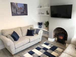 a living room with a couch and a fireplace at Hattie's Cottage in Lincoln