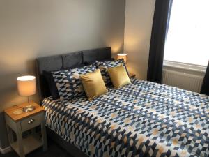 Un dormitorio con una cama con almohadas amarillas y una ventana en Hattie's Cottage en Lincoln
