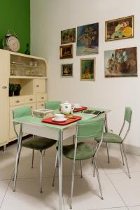 une table à manger avec des chaises et une table verte dans l'établissement Petrucci Garden by Enjoy Napoli, à Naples