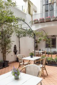 un patio extérieur avec des tables, des chaises et des plantes dans l'établissement Petrucci Garden by Enjoy Napoli, à Naples