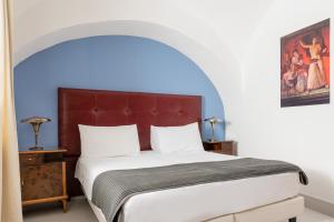ナポリにあるPetrucci Garden by Enjoy Napoliのアーチ型の大型ベッド付きのベッドルーム1室