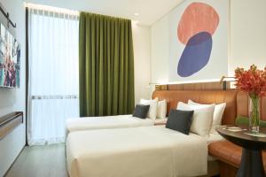 a hotel room with two beds and a window at Citadines Connect City Centre Singapore in Singapore