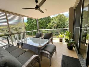 sala de estar con sofá, mesa y sillas en Waterfront Escape 2Bdr, Wavepool, Restaurants, en Darwin