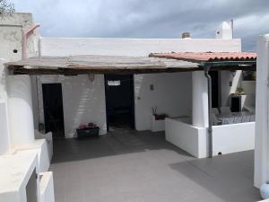 ein weißes Gebäude mit einer Veranda mit einem Dach in der Unterkunft Casa Cristian Stromboli in Stromboli