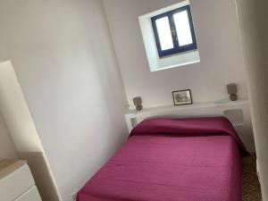 a small room with a bed with a purple blanket at Casa Cristian Stromboli in Stromboli