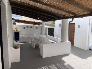 a patio with white furniture and a table and chairs at Casa Cristian Stromboli in Stromboli