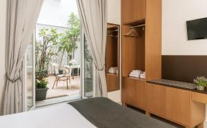 ナポリにあるPetrucci Garden by Enjoy Napoliのベッドルーム1室(ベッド1台付)、パティオに面したガラスのスライドドアが備わります。