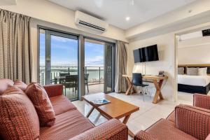 a living room with a couch and a room with a view at Sky high with harbour views in Darwin