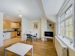 a kitchen and living room with a table and chairs at Duplex Redhill town centre Apt by Livingo Stays in Redhill