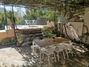 un patio con mesa y sillas bajo una pérgola en Sa caseta des port, en Banyalbufar
