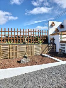 una valla de madera frente a una casa en Alojamento Raminho dos Açores, en Angra do Heroísmo