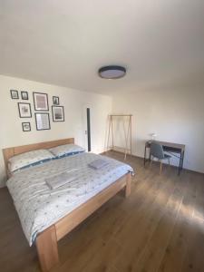 1 dormitorio con cama, escritorio y silla en R-Penzion, en Český Krumlov