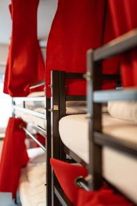 曼海姆Hostel Mannheim的红色座椅的宿舍间内的一组双层床