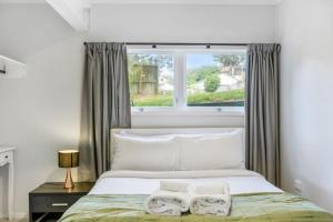 1 dormitorio con 1 cama con 2 toallas en A delight in the Bays - 1 BR - 1 BATH - Free WiFi, en Auckland