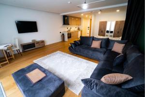 a living room with blue couches and a kitchen at Prime İstanbul Residances Deluxe King Studio in Istanbul