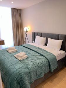 a bedroom with a large bed with two towels on it at Aparthotel Holiday Lux Batumi in Batumi