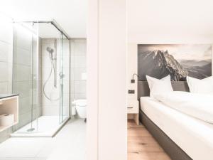 baño con ducha, cama y aseo en Traube Restaurant & Hotel, en Appenzell