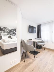 a bedroom with a bed and a table and chairs at Traube Restaurant & Hotel in Appenzell