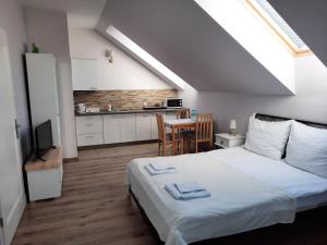 a bedroom with a large white bed and a kitchen at Praski Dom in Sienno