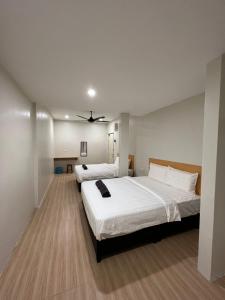 a bedroom with two beds and a ceiling fan at Homestay Suria in Kuala Kangsar