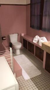 a bathroom with a toilet and a sink with towels at Maison spacieuse, simple, familiale et chaleureuse, Gîte in Malay-le-Grand