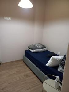 sypialnia z łóżkiem z niebieską pościelą i poduszkami w obiekcie Kassandrou Deluxe Apartment w Salonikach