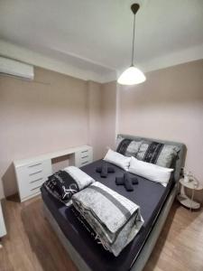a bedroom with a black bed with pillows on it at Kassandrou Deluxe Apartment in Thessaloniki