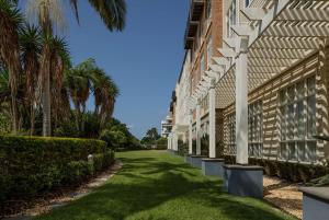 a walkway next to a building with palm trees at Rydges Newcastle in Newcastle