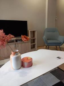 a living room with a table with a vase and a tv at Kassandrou Deluxe Apartment in Thessaloniki