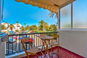 een balkon met een tafel en stoelen en uitzicht op een straat bij Apto 111 El Dorado Playa las Americas By Paramount Holidays in Arona
