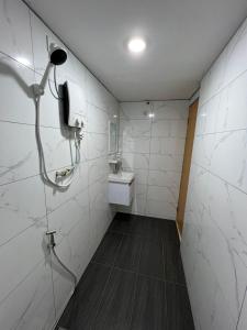 uma casa de banho com um chuveiro e um lavatório. em Homestay Suria em Kuala Kangsar